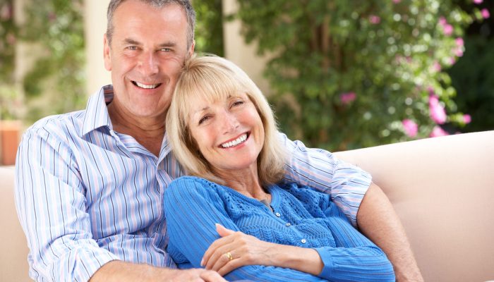 Senior Couple Relaxing On Sofa At Home